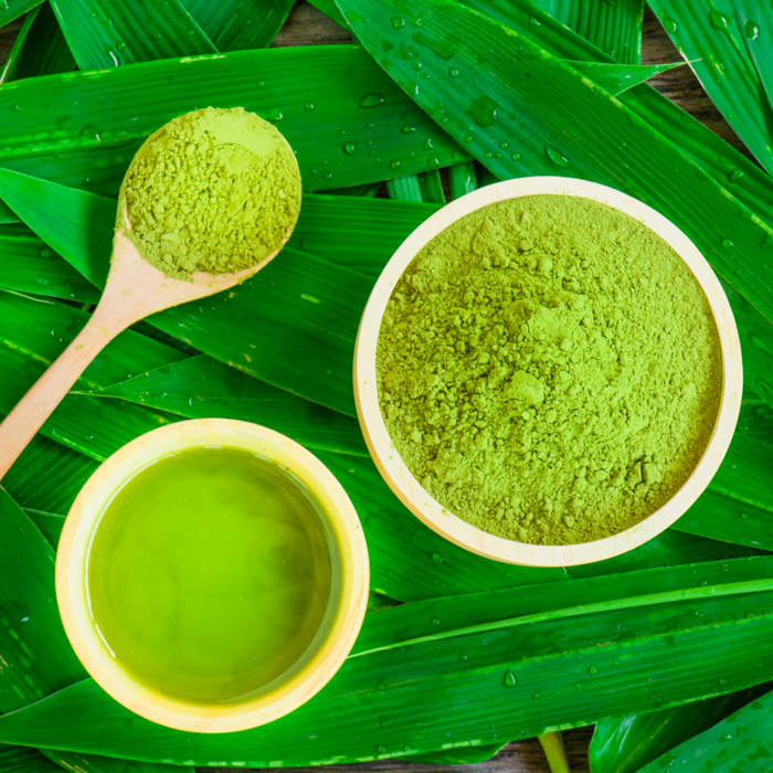 Matcha Green tea and green tea powder on background of leaves