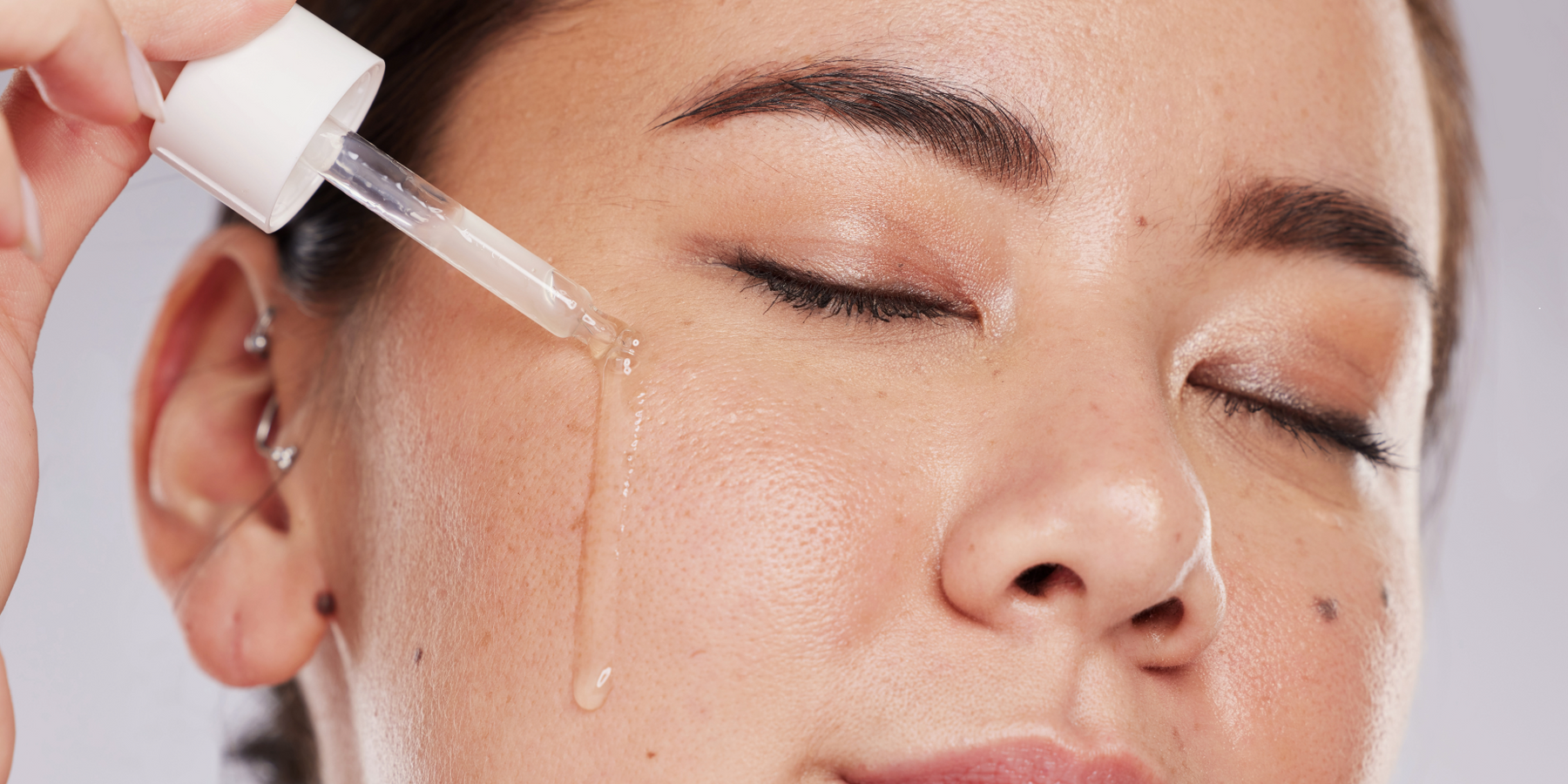 woman applying retinol serum to her face